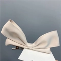 Detailed macro of a beige satin ribbon bow hair clip with sturdy metal duckbill attachment - Duckbill Hair Clips / Beige