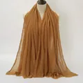 Caramel brown pleated cotton linen scarf with frayed edges displayed on a mannequin - Caramel color