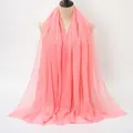 Pink crinkle cotton linen scarf with frayed edges displayed on a neutral mannequin - Pink