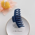 Matte navy blue large shark hair claw clip displayed on a decorative white porcelain plate - Navy Blue
