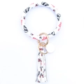 Detail of white PU leather wristlet keychain with gold metal ring and tassel charm - Eye
