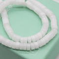 Macro view of white natural stone abacus beads on a light green jewelry box surface - White Jade