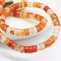 Macro detail of natural stone abacus beads showing orange carnelian texture and semi-translucency - Red Aventurine