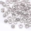 Close-up of bright silver flower petal bead caps for DIY jewelry making on white background - GPHJ031