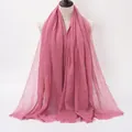 Dusty rose crinkled cotton linen scarf with frayed edges for women shown on a mannequin - Dark Pink
