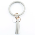 Detail of light grey faux leather keychain bracelet with golden metal ring and tassel charm - Gray