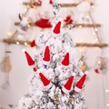 Mini cappelli di Natale rossi con pompon bianchi su rami di alberi innevati - Mini Cappello di Natale / Rosso