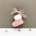 Detalle de llavero de bota navideña de felpa rosa con piel sintética blanca y cierre dorado - Rosa