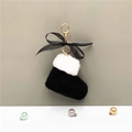 Close-up of plush Christmas boot keychain with black bow and golden lobster clasp - Black