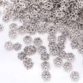 Macro shot of vintage silver flower bead caps for DIY jewelry and bracelet crafting - GPHJ038