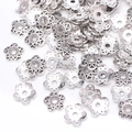 Close-up of silver hollow five-petal flower bead caps for DIY jewelry making - GPHJ035
