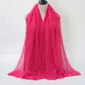 Solid rose pink crinkle cotton scarf with raw fringe edges on a mannequin - Rose Red