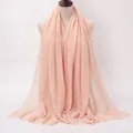 Light peach pink pleated cotton scarf with frayed edges for women shown on mannequin - Light Pink