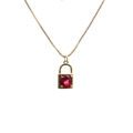 Close-up of golden necklace featuring a micro-pave padlock pendant with a red gemstone - Lock 9 Red-Ruby Lock