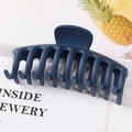 Close-up of a large navy blue matte claw clip with a unique geometric dragon bone design - Matte Ink Blue