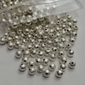 Macro shot of silver frosted metal round beads with textured finish and center holes - 3mm / Silver