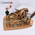 Detailed view of camel paisley silk scarf with vintage geometric prints on white background - Camel