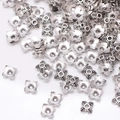 Macro shot of silver flower bead caps with engraved patterns for DIY jewelry making - GPHJ033