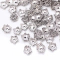 Detailed macro view of antique silver flower bead caps for DIY jewelry crafting - GPHJ048