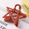 Macro shot of matte brick red star-shaped hair claw clip with cutout geometric details - 7.5cm / Red
