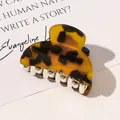 Detailed close-up of tortoise shell pattern acrylic hair claw clip on magazine - Tortoiseshell / Leopard Coffee