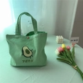 Detail des Magnetverschlusses einer grünen Canvas-Tasche mit Avocado-Aufdruck - Minzgrüne Avocado