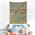 Van Gogh Almond Blossoms tapestry hanging on a white wall above a modern armchair - Blossoming Almond Branch in a Glass