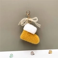 Detail of plush Christmas boot keychain with ginger fur and white lace bow decoration - Yellow