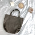 Detailed view of dark olive green corduroy tote bag with vintage gold metal snap fastener - Earth Tone