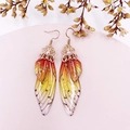 Detailed macro view of cicada wing earring with orange gradient resin and gold flakes - Orange-Gold Foil