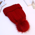 Detail of red cable knit beanie with large faux fur pompom and thick cuffed edge - Burgundy