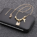 Detail of gold necklace with micro-pave rhinestone lock and key pendants on black box - Style 1 Copper Beads Lock and Key
