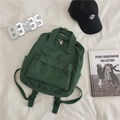 Dark green canvas backpack with front pocket and top handle on a casual background - Without Pendant / Green