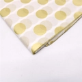 Nahaufnahme von Seidenpapier mit glänzenden goldenen und matten beigen Polka-Dot-Mustern - Goldene Punkte