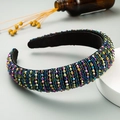 Macro shot of handcrafted baroque headband with multi-color beads and black velvet lining - Colorful