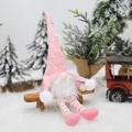 Gnomo di Natale in maglia rosa con luci LED e gambe lunghe su una panca di legno - Motivo a Pois Rosa / Rosa