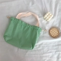 Detail of mint green canvas drawstring bag with off-white handles on soft fabric - Mint Green
