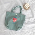 Detail der hellgrünen Canvas-Tasche mit Erdbeer-Print und Metall-Verschluss - Haze Blue Strawberry