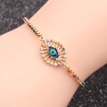 Dettaglio del bracciale occhio portafortuna dorato con zirconi colorati sul polso - Stile Malocchio con Zirconi Colorati 4