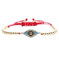 Macro detail of red woven chain bracelet with blue zircon evil eye charm in gold - Red Rope Bead Chain Evil Eye - Style 7