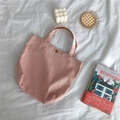 Detailed view of pink canvas tote bag with metal snap button closure and woven handles - Skin Pink