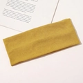 Detailed view of ginger yellow knitted headband featuring elastic ribbed cotton texture - Turmeric