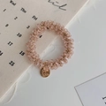 Pink crystal beaded hair tie with a gold Joy White engraved pendant on linen background - Crystal Pink