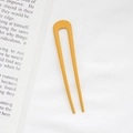 Minimalist yellow U-shaped hair pin for bun styling displayed on a white fabric background - Ginger Yellow