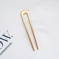 Minimalistische goldene Haarnadel in U-Form für elegante Dutts auf hellem Hintergrund - U-Förmig Mattgold