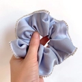 Blue satin scrunchie with rhinestones edge detail shown in a hand-held close-up - Sky Blue