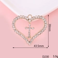 Macro shot of gold-plated heart cross pendant with inlaid rhinestones on pink background - D230 Heart Cross
