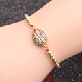 Pulsera de concha dorada con circonitas de colores y cordón trenzado rojo ajustable - Concha de Zirconia Colorida