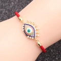 Dettaglio di modella che indossa un bracciale occhio greco in oro e zirconi colorati - Malocchio 4 (B0071)
