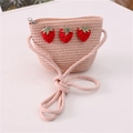 Detail of pink straw crossbody bag for kids featuring cute red strawberry patches - Three Strawberries Style / Light Pink